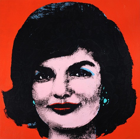 A screen printed portrait of Jackie Kennedy. Her skin is a pale pink, her lips deep red, and tiny blue earrings peak out from under her bobbed hair. The background of the image is a striking bright red.
