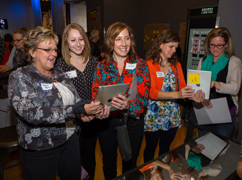 Group of five teachers smiling and holding iPads.